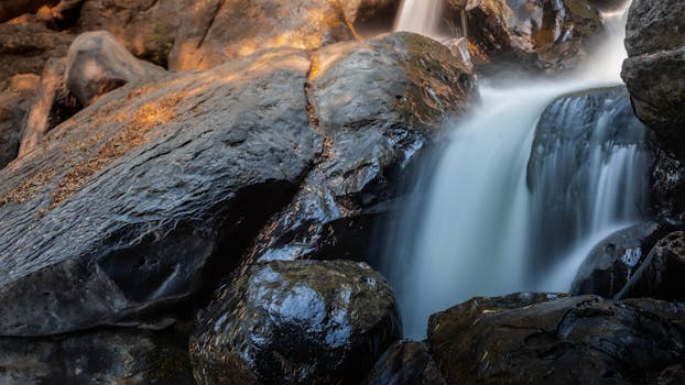 宁静的瀑布轻轻流过岩石，在大自然中营造出一片宁静的景观