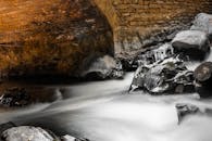 石拱桥下，溪流宁静的长曝光镜头捕捉了自然之美