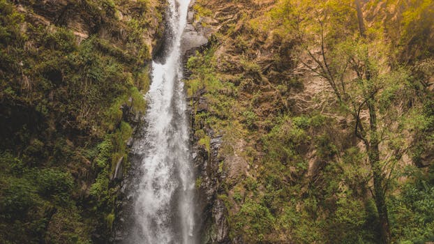 在宁静的户外环境中，壮丽的瀑布沿着郁郁葱葱的绿色悬崖边层层叠落