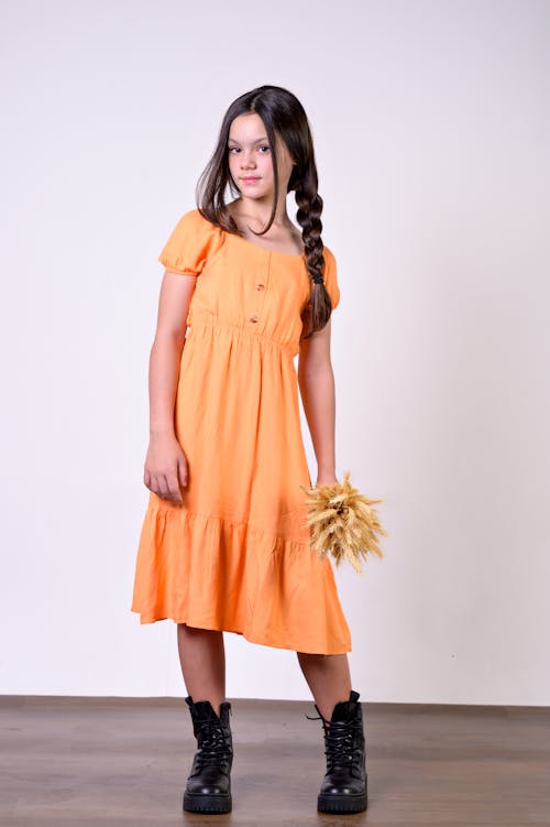 A girl in an orange dress and boots