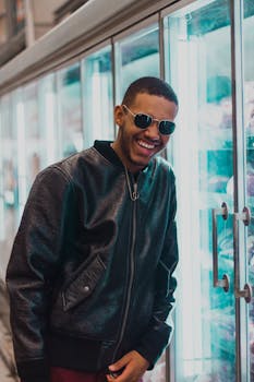 一个时尚男人戴着墨镜和皮夹克在室内笑