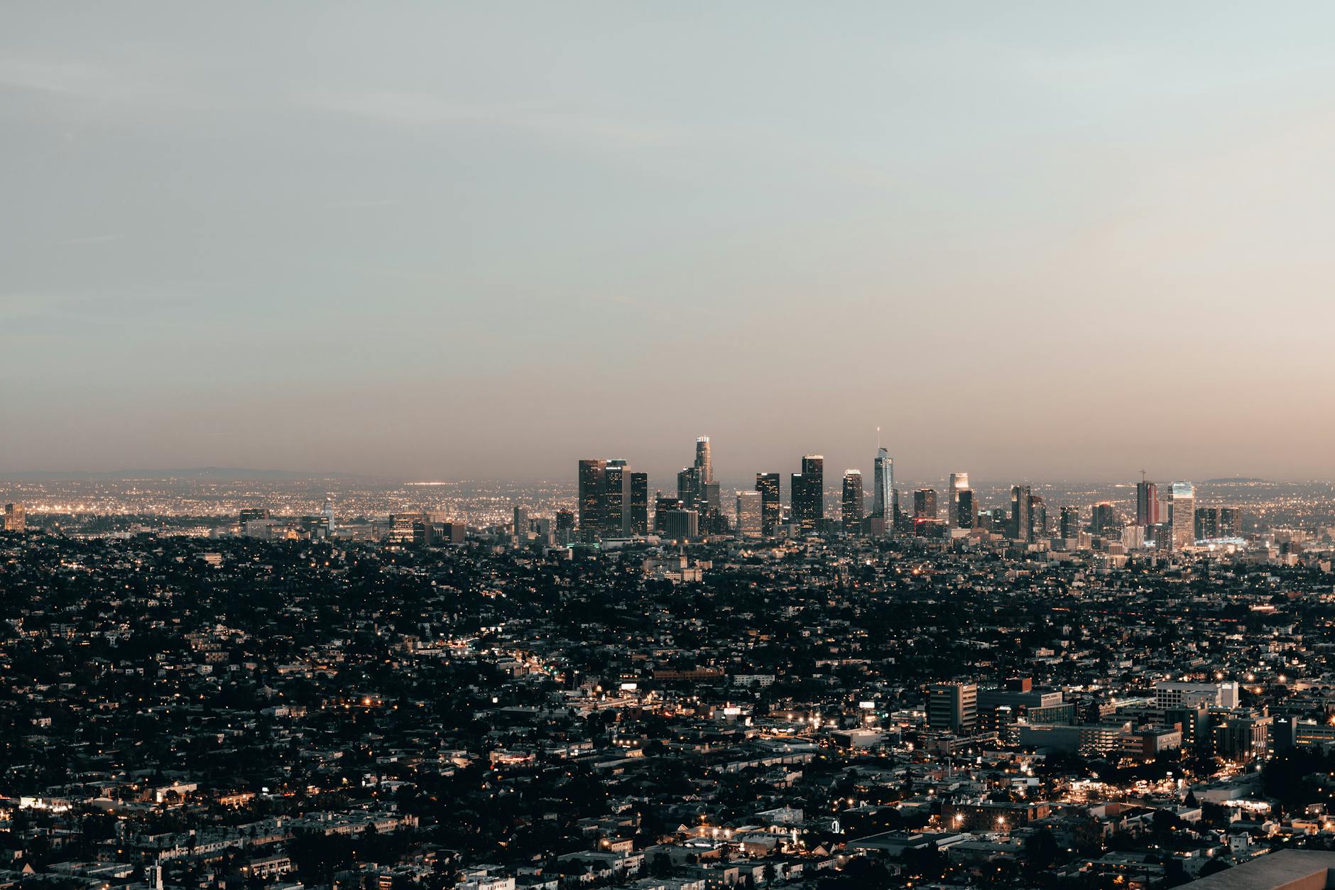 Aerial view of Hollywood Hills luxury mansions overlooking the Los Angeles skyline at sunset