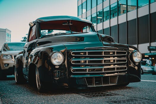 一辆经典的黑色老爷车停在城市街道上，展现出永恒的汽车优雅