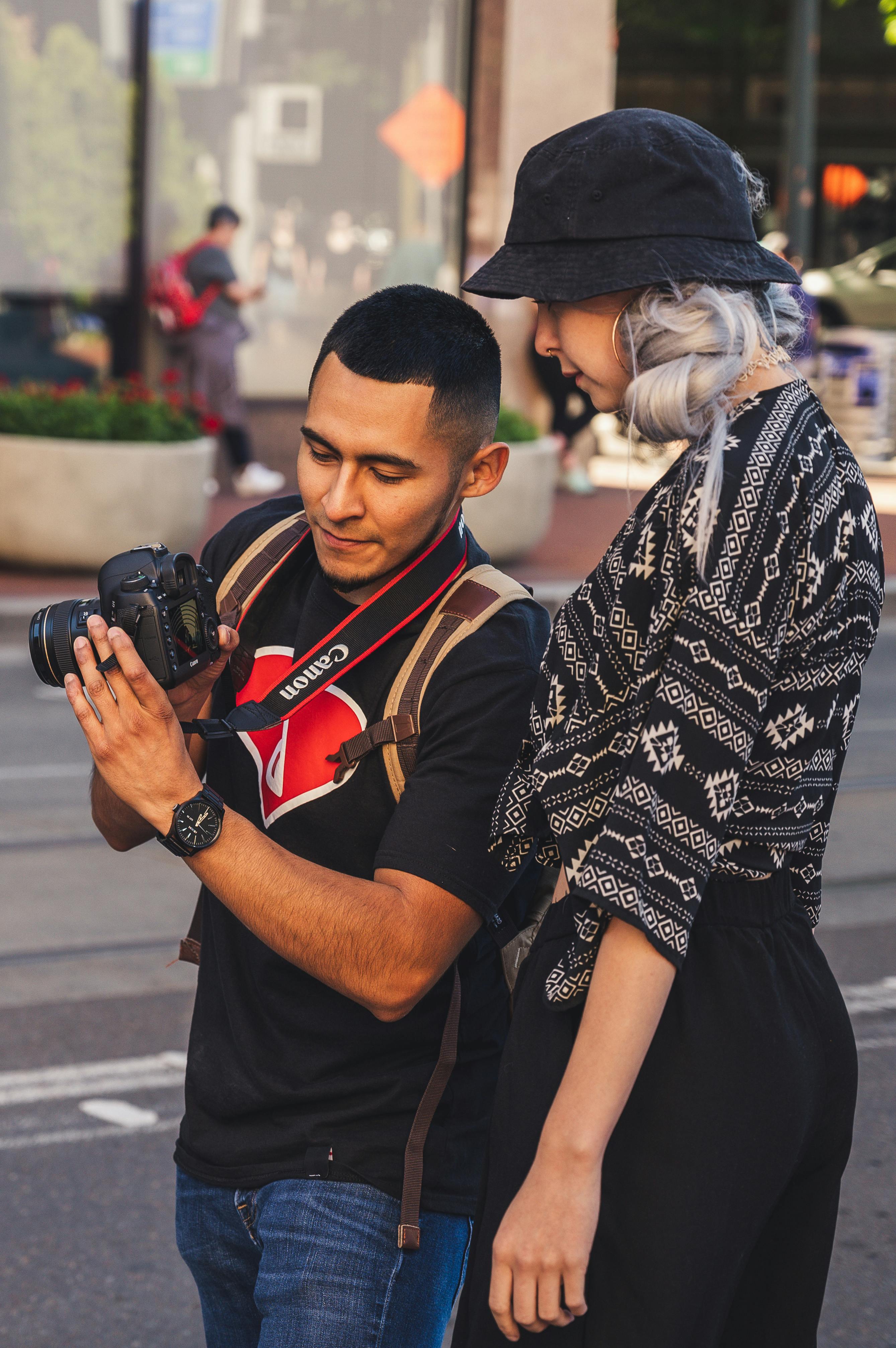 Two photographers review camera settings during a street session.