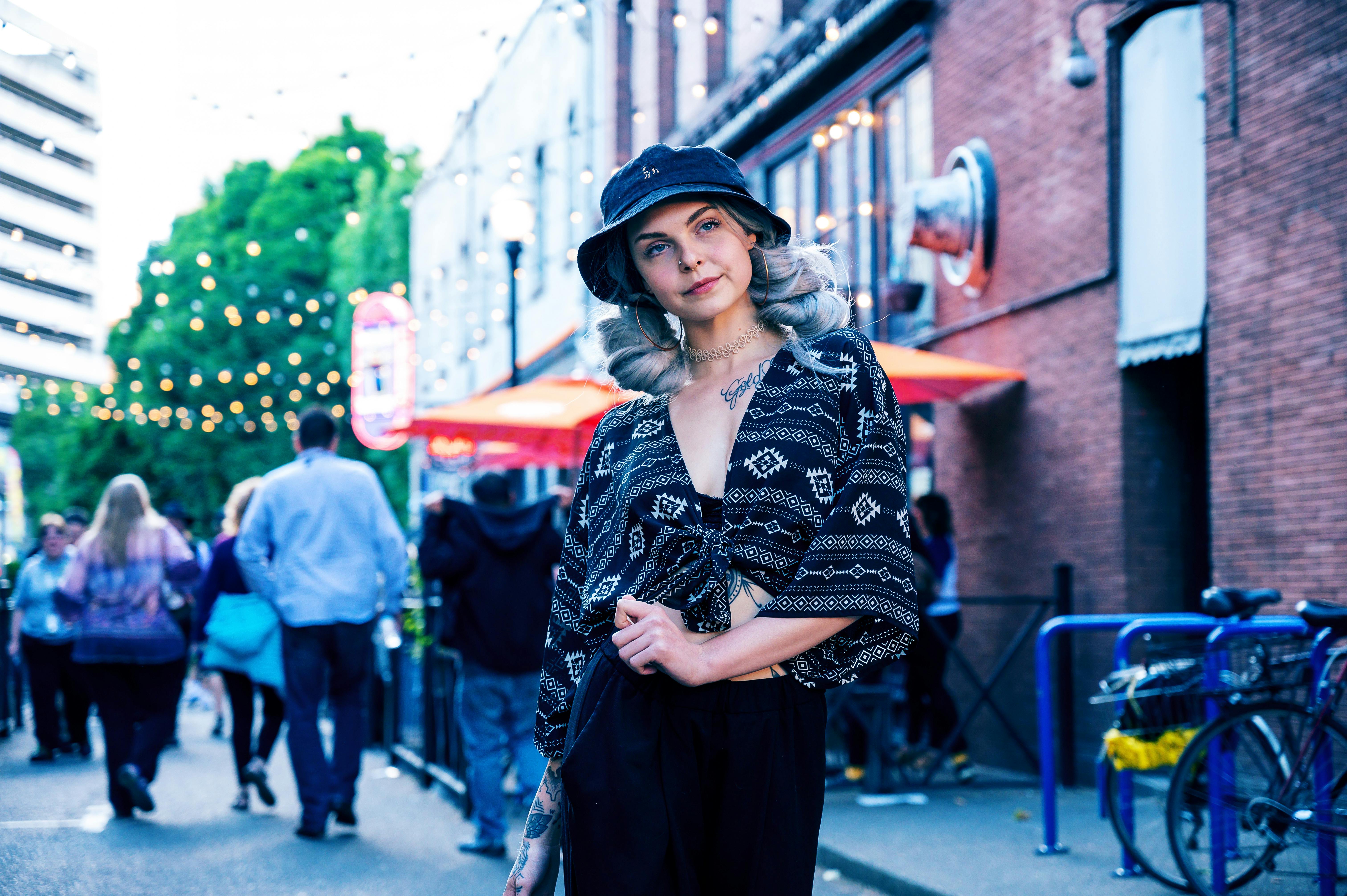 Stylish woman with silver hair posing in a vibrant city street during the day.