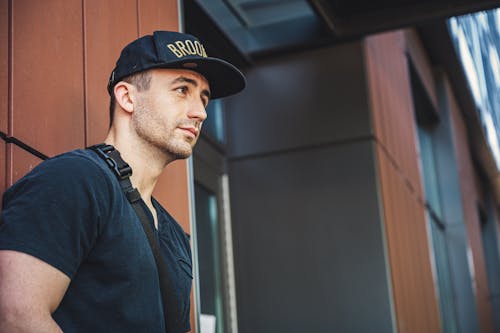 Foto De Enfoque Superficial Del Hombre En Camiseta Negra Vistiendo Una Gorra De Ala Plana