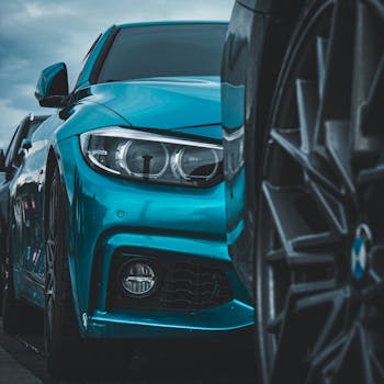 Front view of a sleek blue luxury car, showcasing its modern design and headlight features.