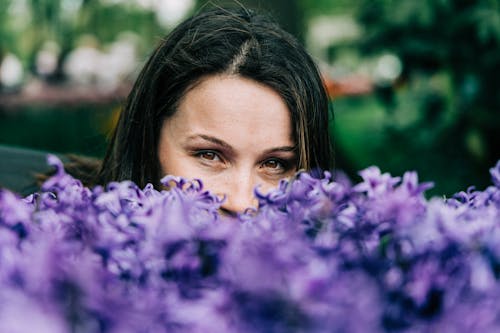 Woman Behind Purple Flowers