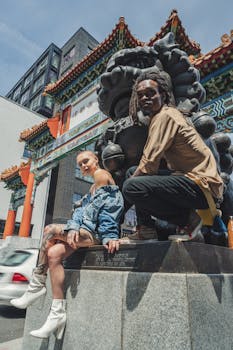 一对时尚的二人组在传统的亚洲大门和雕塑旁摆姿势