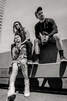 三位成年人在城市时尚的屋顶上摆出不同姿势，捕捉现代友谊的瞬间