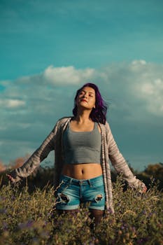 一位紫发年轻女子在绿野中，享受着阳光明媚的一天，拥抱大自然