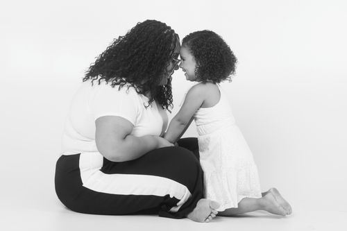 Free A touching black and white portrait of a mother and daughter in an affectionate pose. Stock Photo