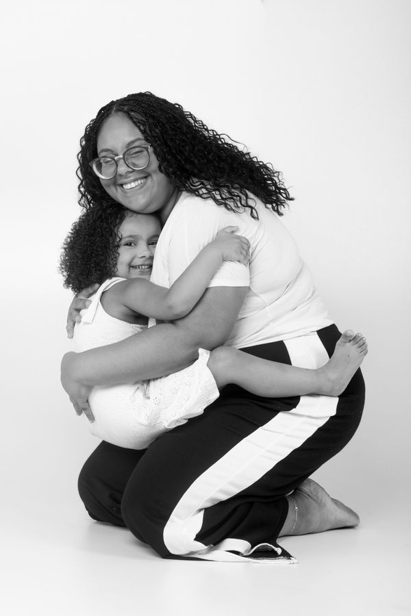 Mother hugging her daughter in a black and white studio portrait