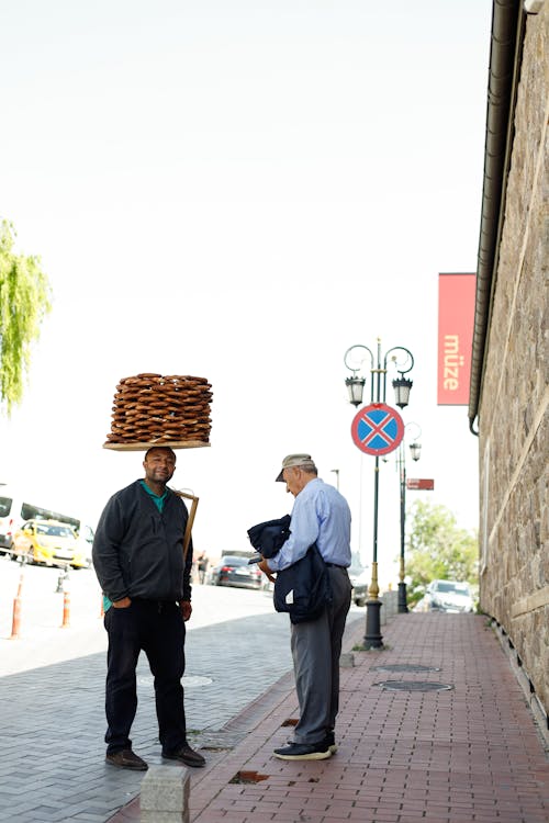 A man carrying a tray of donuts on his head