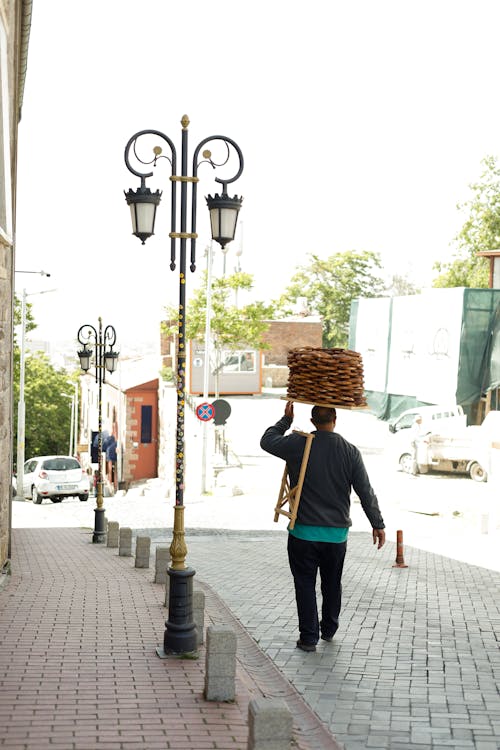 A man walking down the street carrying a basket