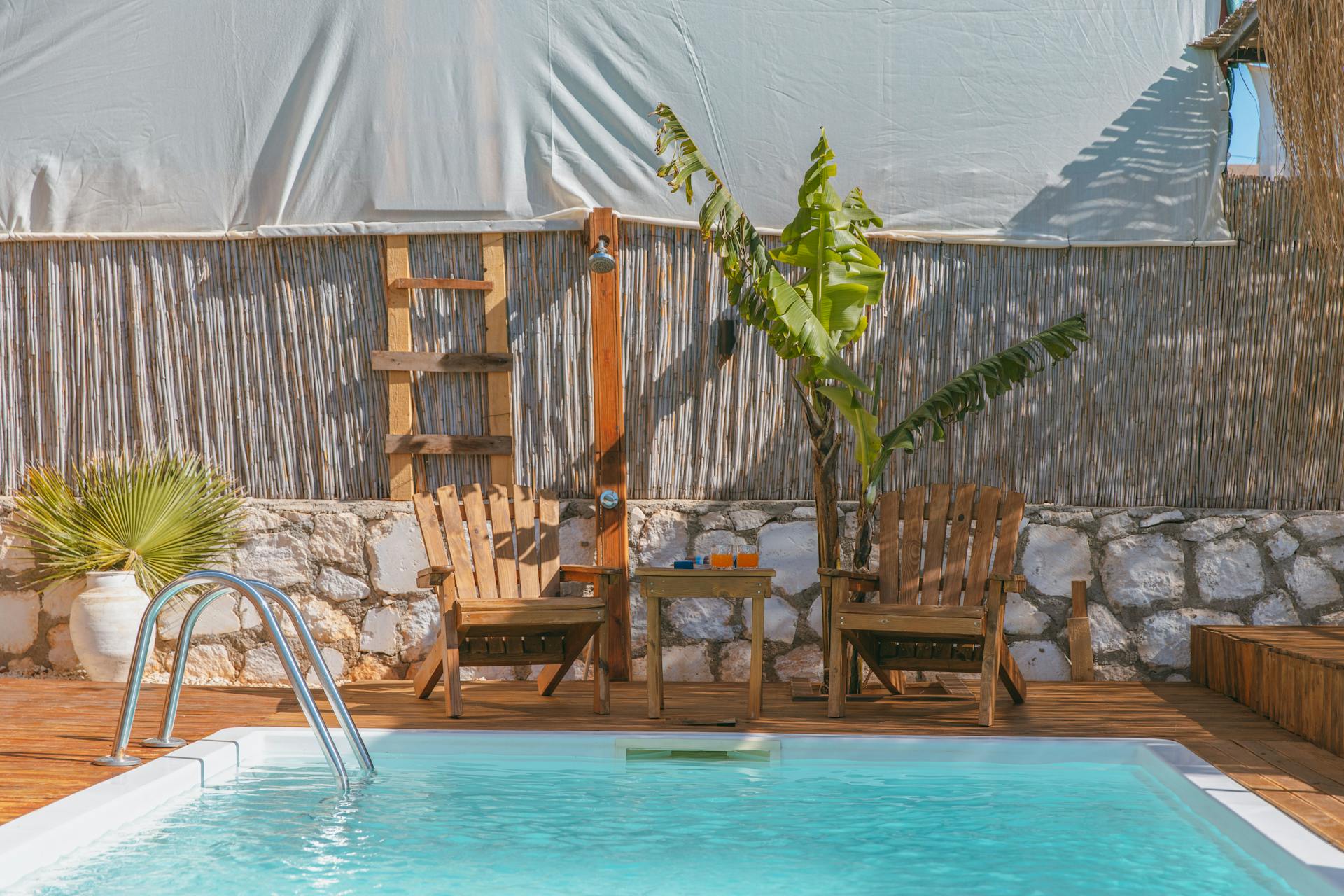 Chairs and a Table Standing on the Deck by the Swimming Pool