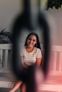 一位开朗的女人被铁链束缚在室内的长凳上，散发出温暖的共鸣