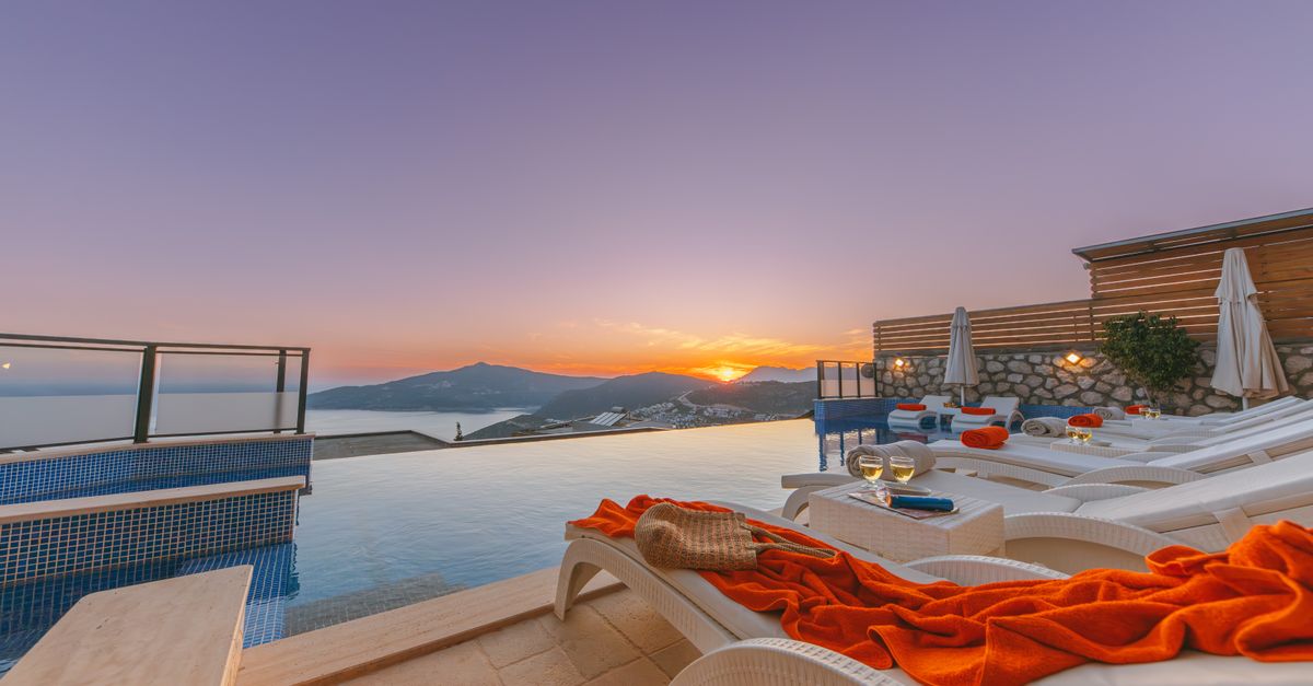 Luxury infinity pool villa overlooking the ocean at sunset