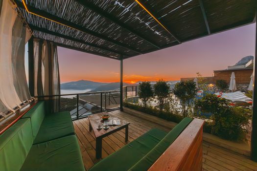 Elegant terrace with cozy seating offering a breathtaking sunset view.