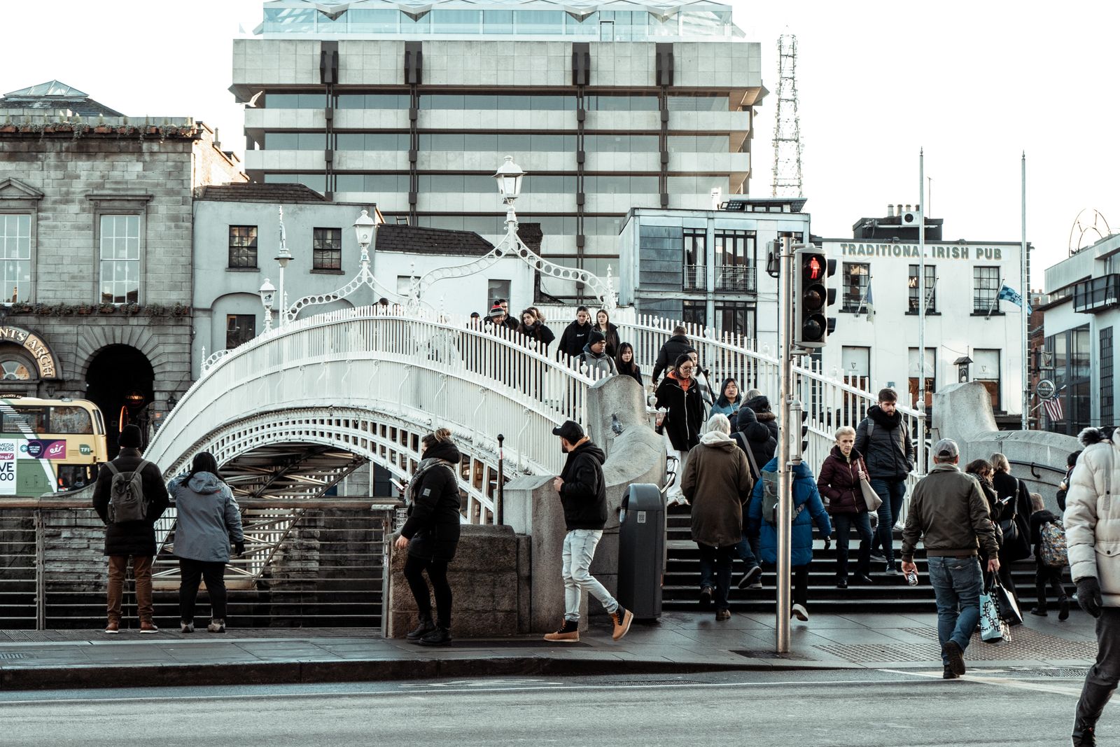 Crowd crossing the iconic Ha'penny Bridge in Dublin, showcasing city life