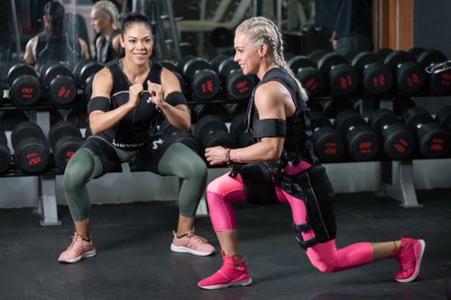 Free Two women engaged in strength training at a gym, showing determination. Stock Photo