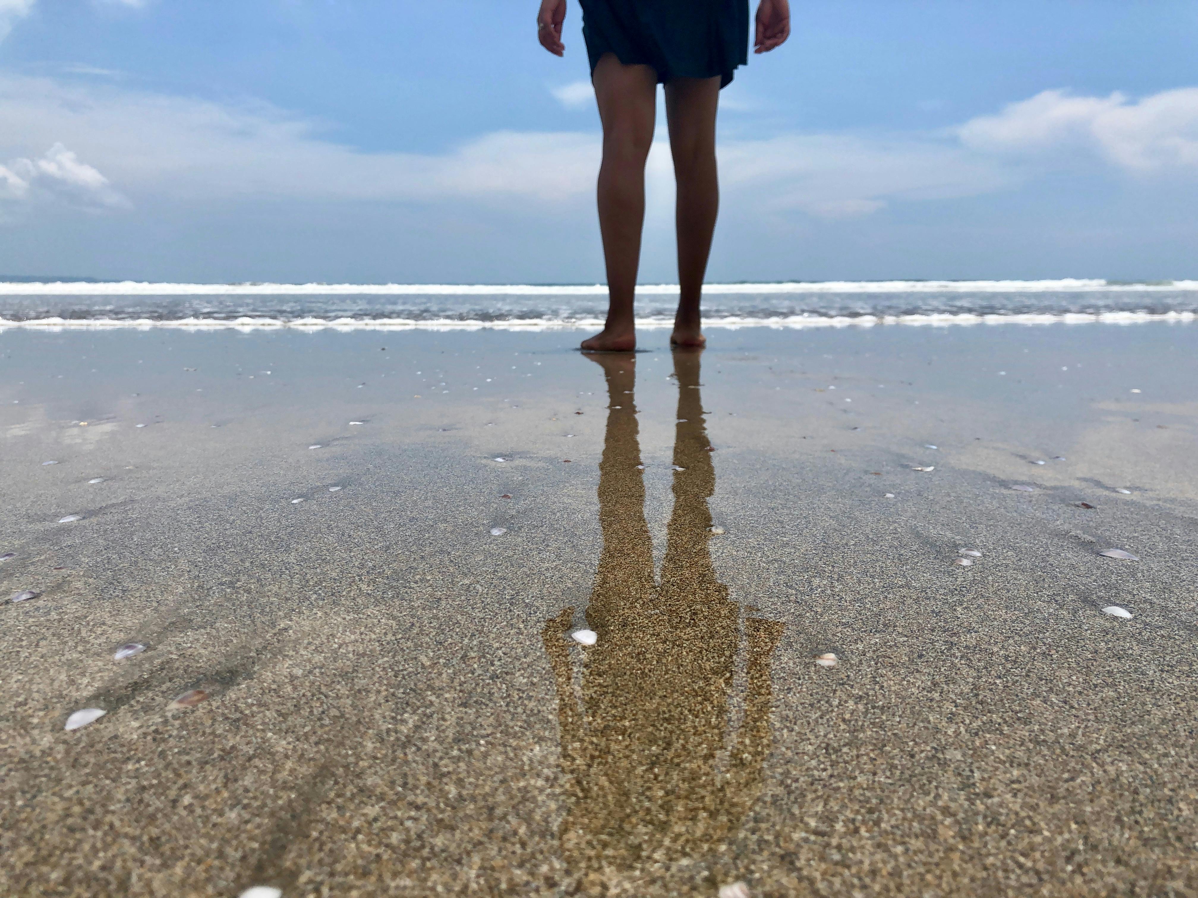 Beach, man with feet in the water, sand