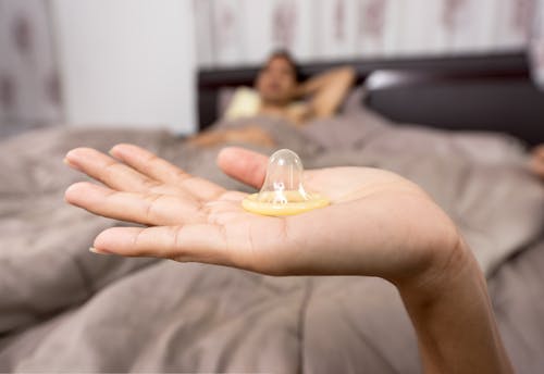 бесплатная Крупный план женщины, держащей презерватив Стоковое фото