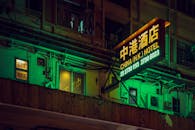 霓虹灯照亮的酒店标志点亮了香港繁华的街道，捕捉着这座城市充满活力的夜生活