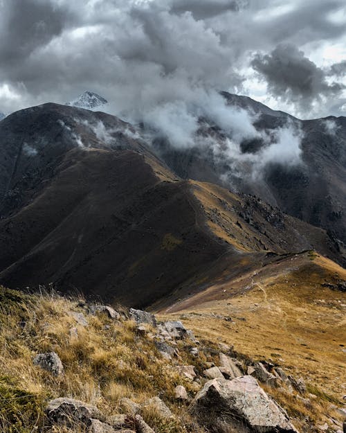 Free Majestic Almaty highlands, clouds over rugged peaks and tranquil autumn valleys. Stock Photo