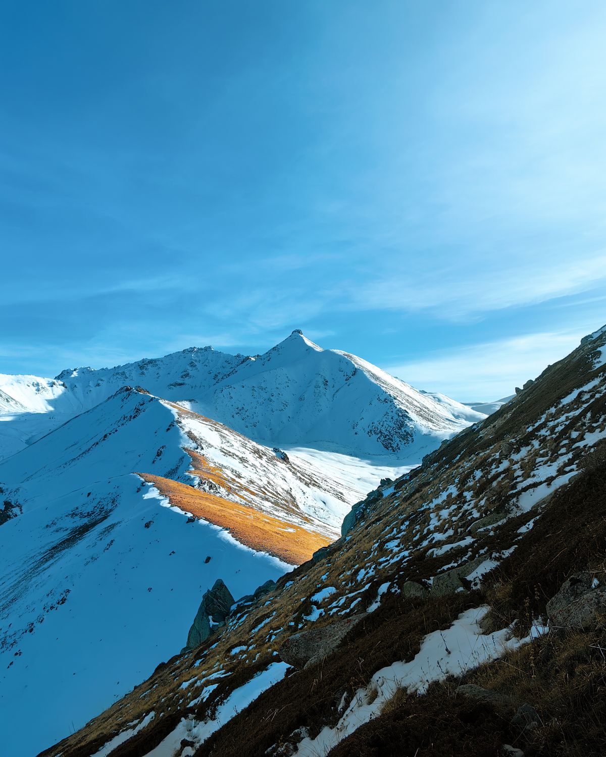 Snow-capped peaks of the Ile-Alatau mountains above Almaty Kazakhstan under clear blue sky