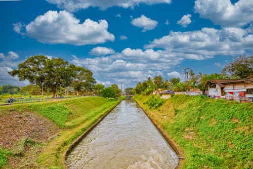 A canal with a bridge and grassy area