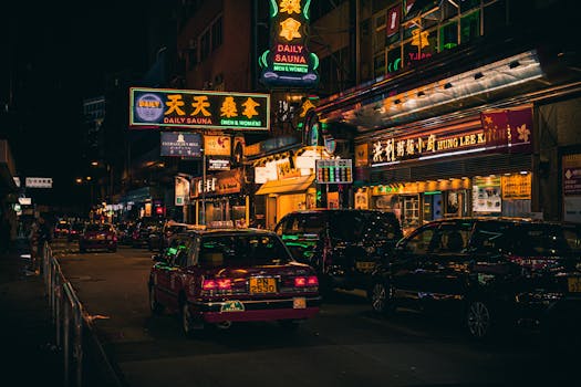 Explore the bustling nightlife of Hong Kong with vibrant neon signs and iconic taxis on a lively street.