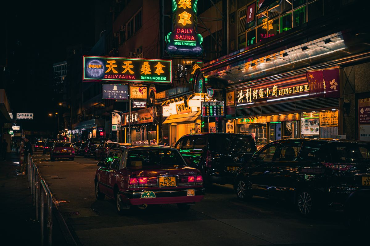 Cars beside neon signages in Hong Kong street