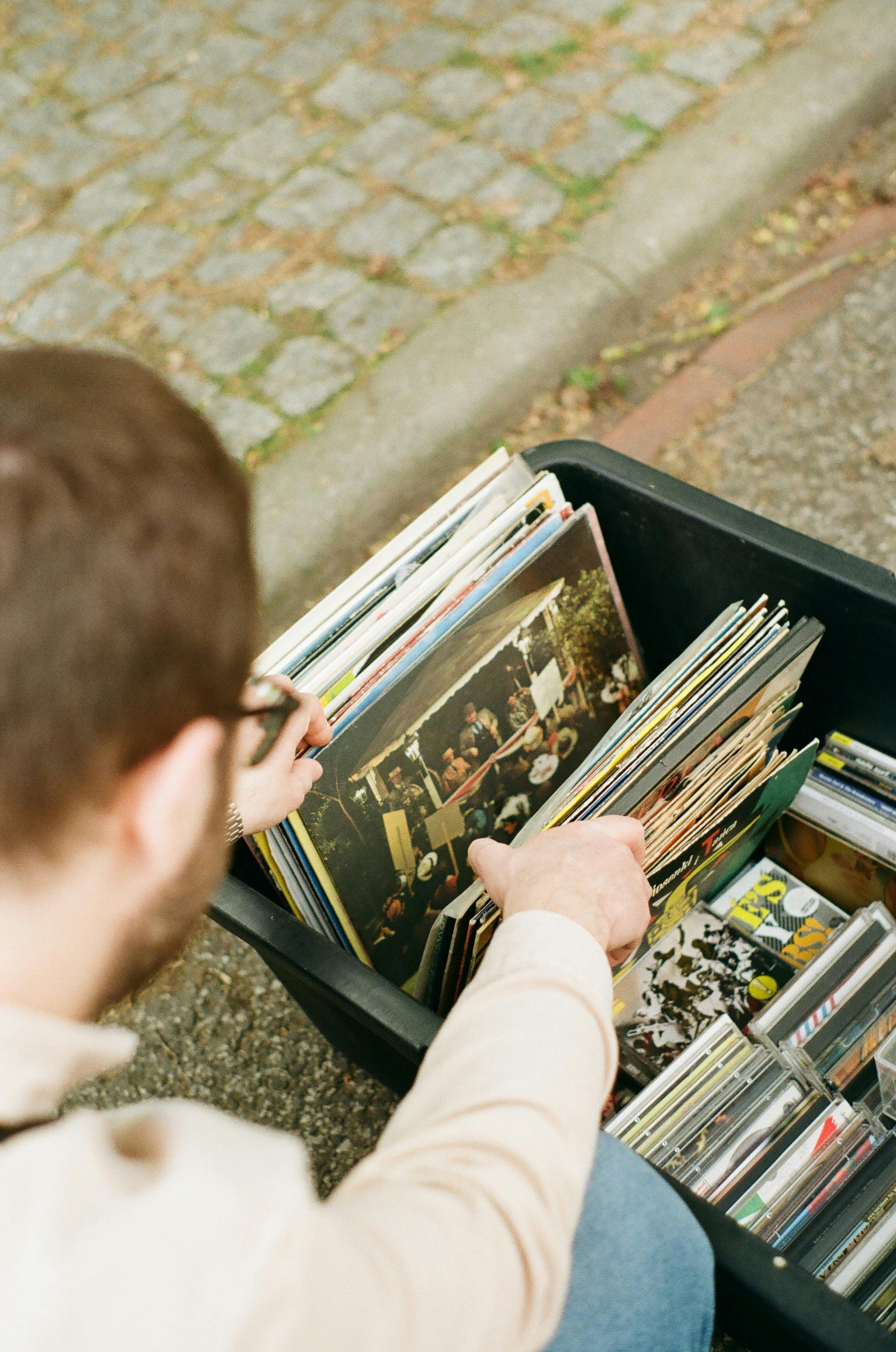 Man exploring vintage vinyl records collection in a street market.