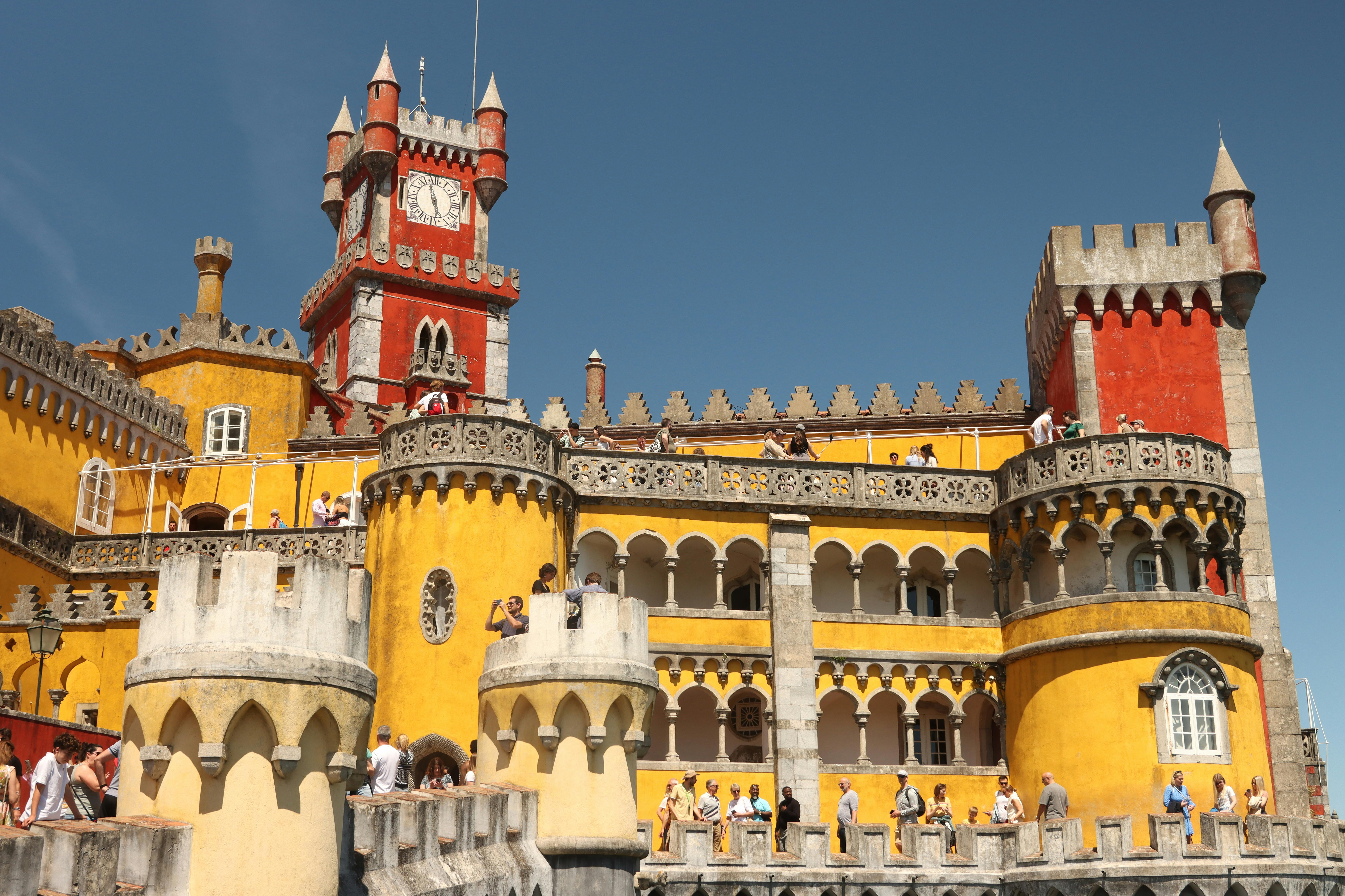 Vibrant exterior of the Pena Palace in Sintra, Portugal, showcasing Gothic and Romantic architectural styles.