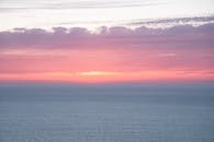 摩洛哥丹吉尔的海面上，日落充满活力，泛着粉红与紫色的色调