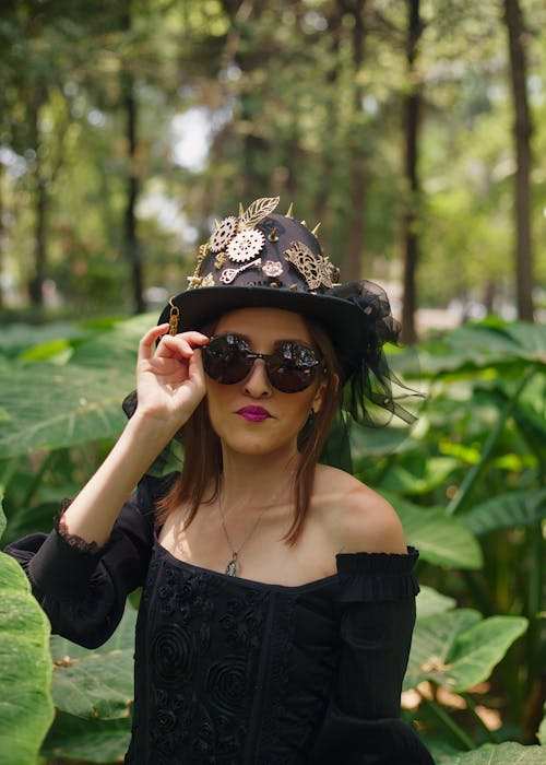 A woman in a hat and sunglasses in the woods