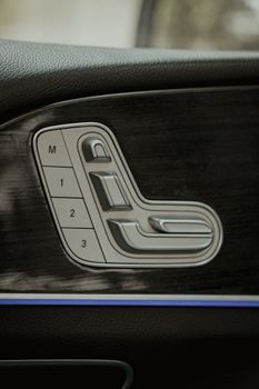 Close-up of a car seat adjustment panel showing buttons and sleek design.