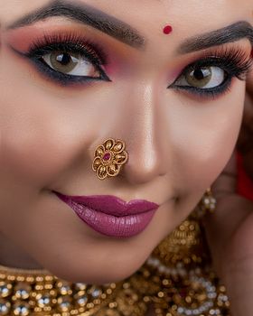 Detailed close-up portrait of a woman with elegant traditional makeup and jewelry.