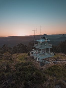Aerial shot of a radar tower amidst Australian wilderness, captured during sunset.