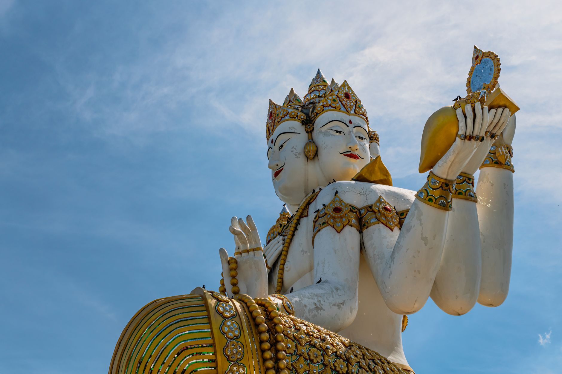 Intrincada estatua de Brahma en Wat Saman Rattanaram contra un cielo azul claro en Bangkok, Tailandia.