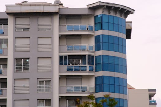 Contemporary apartment building facade with blue glass and balconies in Bornova, İzmir.