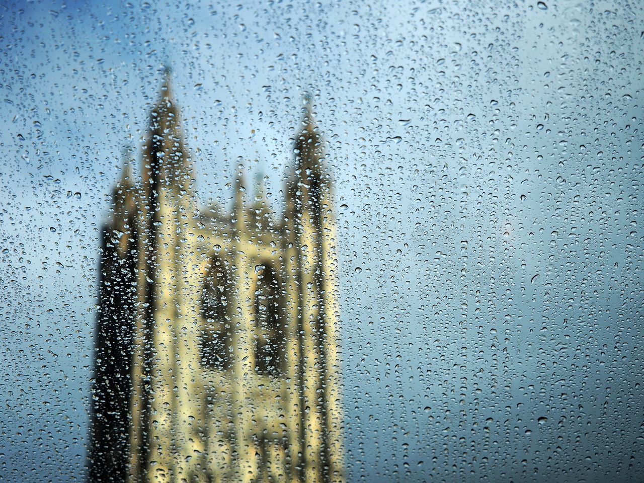 view of a blurred cathedral tower seen through rain soaked glass creat