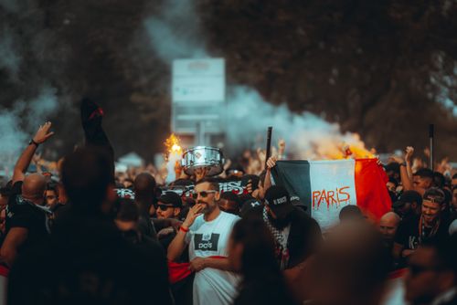 Free A lively crowd of football fans celebrating with smoke flares and flags in Paris streets. Stock Photo