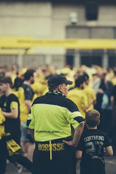 Crowd of Borussia Dortmund fans outside stadium in spirited yellow jerseys before football match.