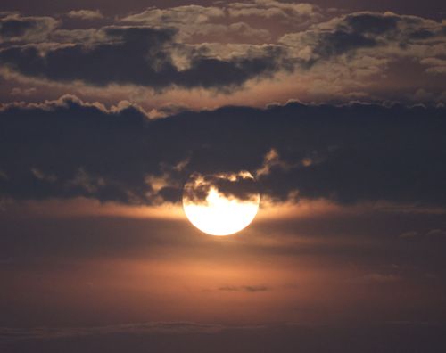 Free A captivating view of the full moon behind dense clouds during a twilight evening in Stamford, CT. Stock Photo