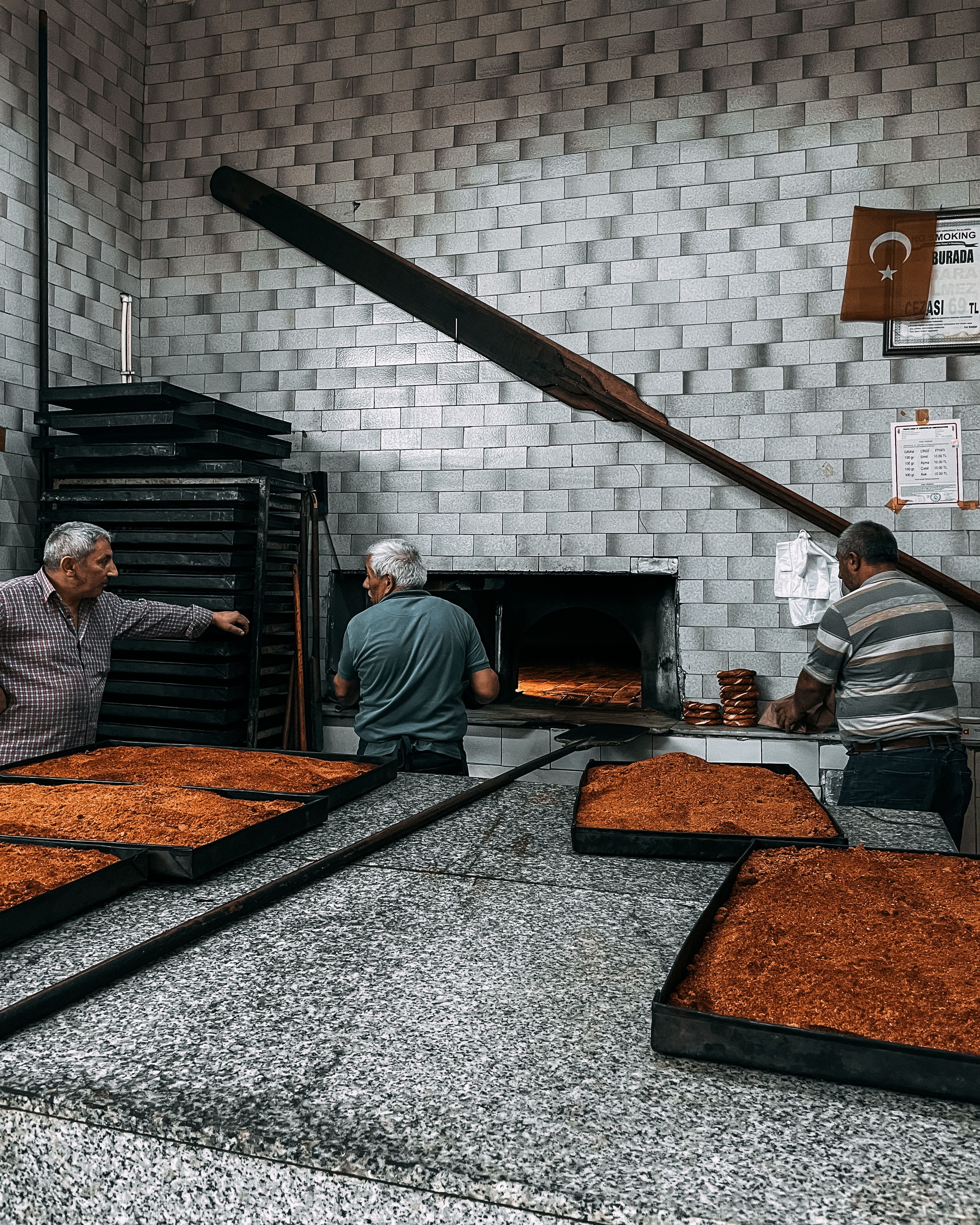 Middle Eastern men baking flatbread in a traditional stone oven, showcasing authentic culinary techniques.
