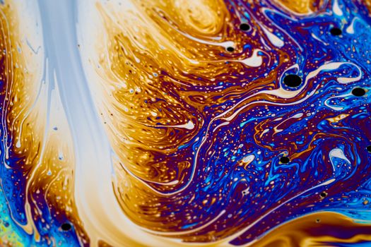 Colorful abstract swirl pattern with blue and gold hues creating a mesmerizing visual effect.