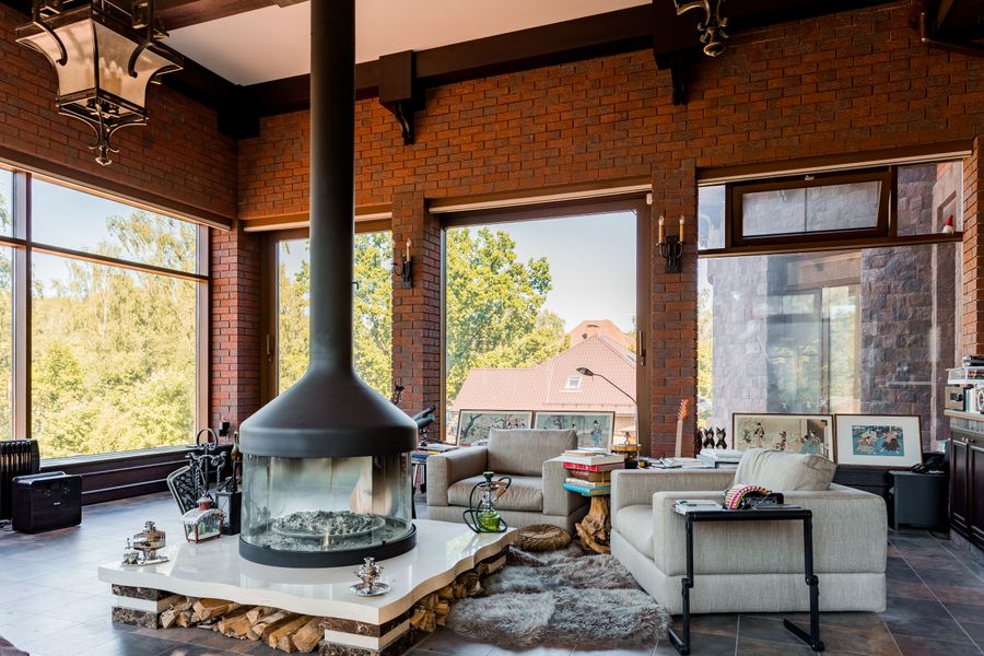 Spacious living room with large windows and a modern fireplace, staged and lit for real estate listing photography