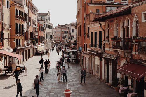 Free Explore a bustling Venetian street showcasing historic architecture and vibrant urban life. Stock Photo